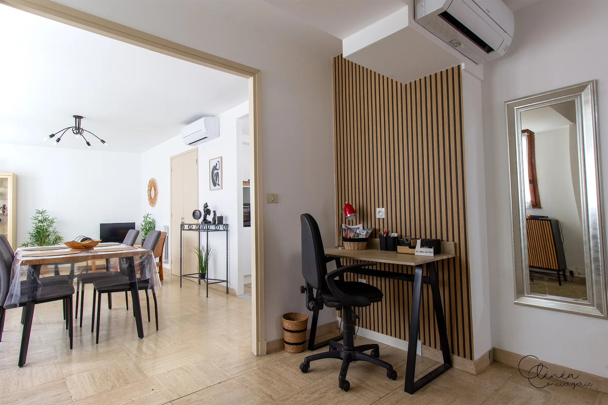 Au Cœur des Lices — Coin bureau adossé à un mur en tasseaux de bois, avec fauteuil à roulettes et climatisation murale.