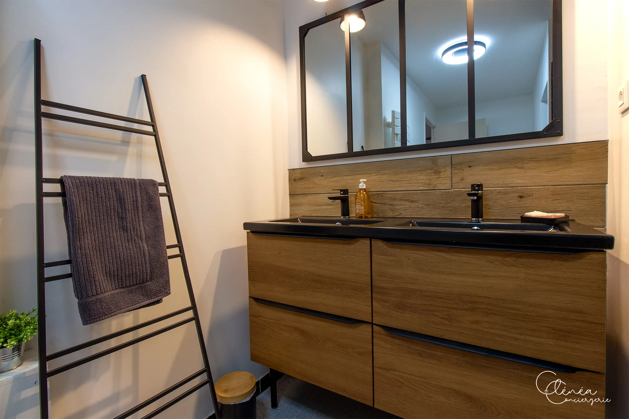 Au Cœur des Lices — Le meuble double vasque de la salle de bain et son porte-serviettes en échelle.