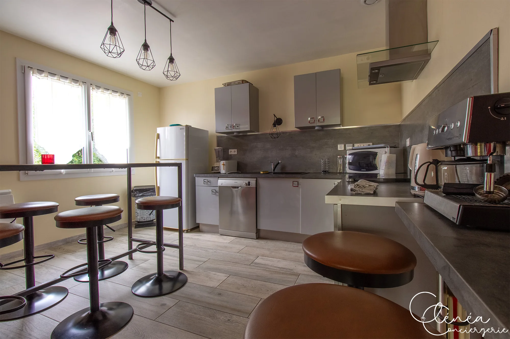 L’Escapade Albigeoise — Cuisine équipée avec réfrigérateur, lave-vaisselle et table mange-debout entourée de tabourets
