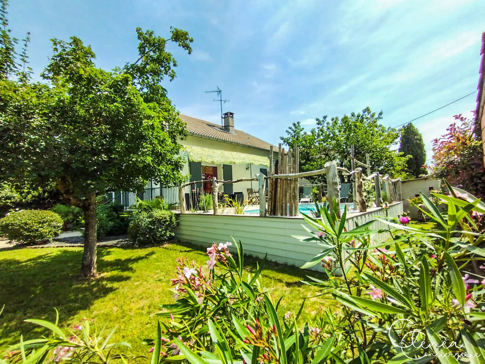 L’Escapade Albigeoise — Le jardin en pelouse au premier plan, avec des lauriers-roses et, en arrière-plan, l’espace piscine surélevé