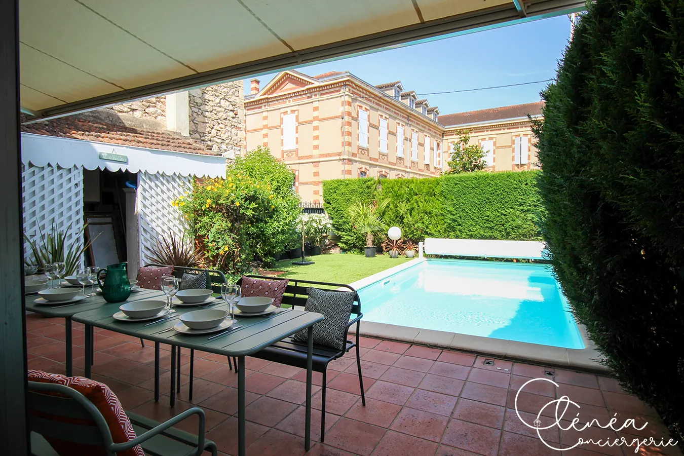 Évasion — Grande table dressée sur la terrasse carrelée, face à la piscine
