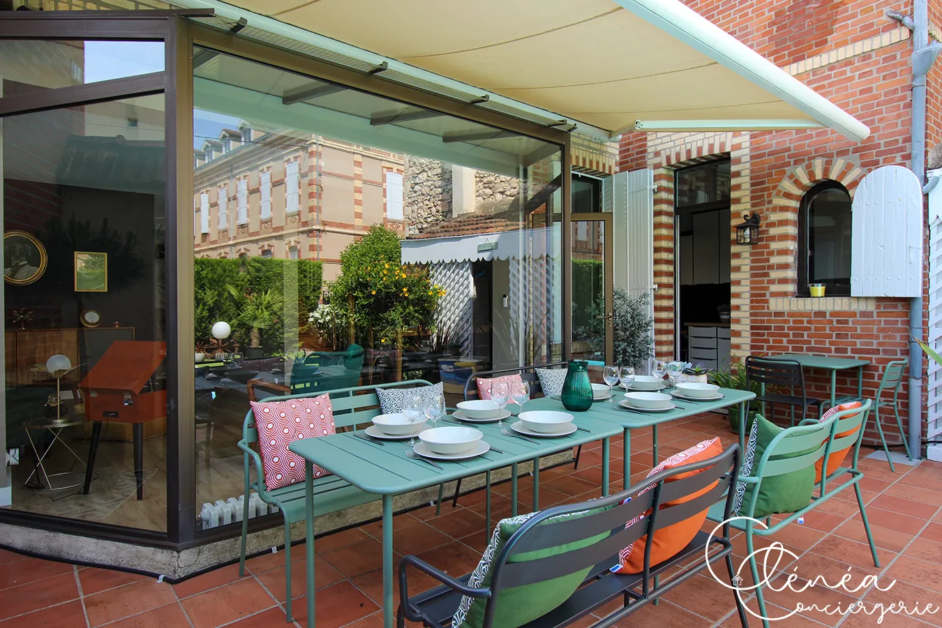 Évasion — Table de repas dressée sous la véranda, ouverte sur le jardin