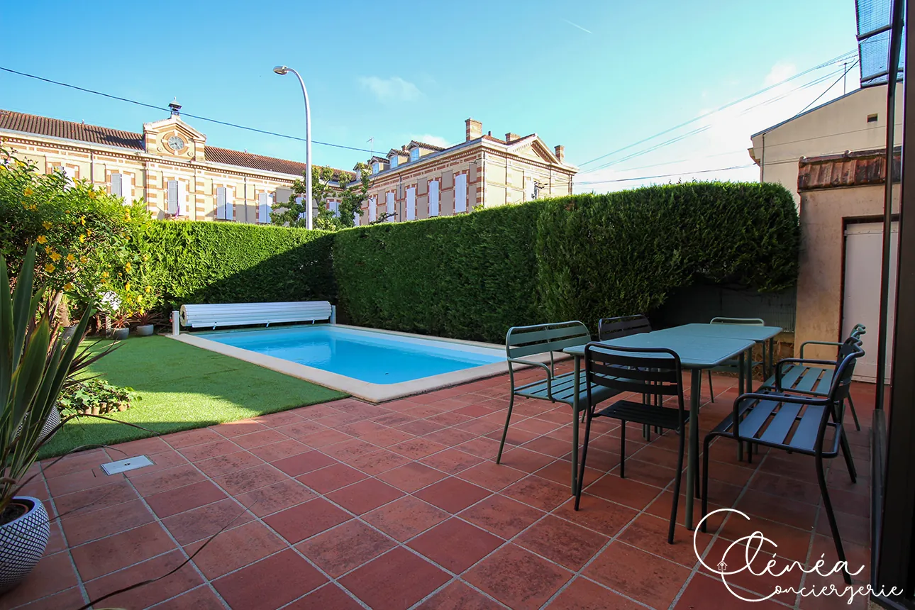 Évasion — Terrasse carrelée avec salon de jardin, piscine et pelouse en arrière-plan