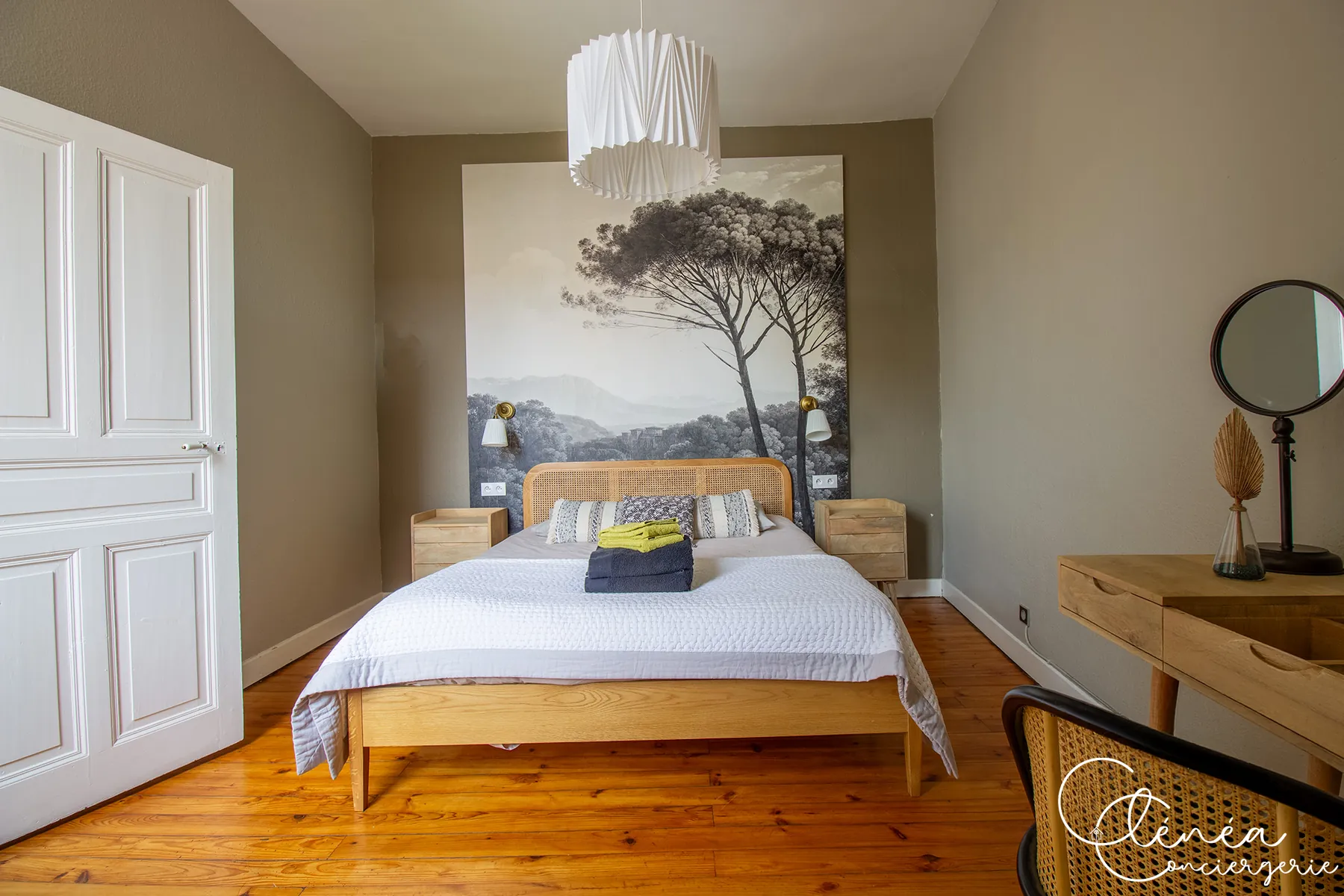 Évasion — Chambre Le Cocon d'Antan : lit en bois devant une fresque murale d'arbres