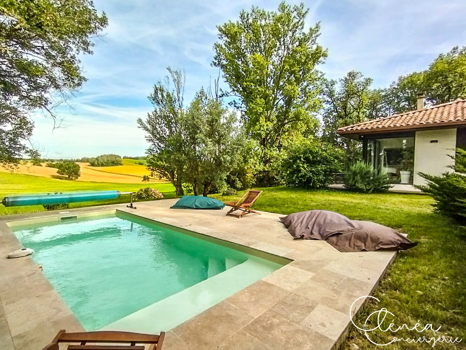 GreenOak — Piscine au premier plan avec vue dégagée sur les champs cultivés et la maison sur la droite