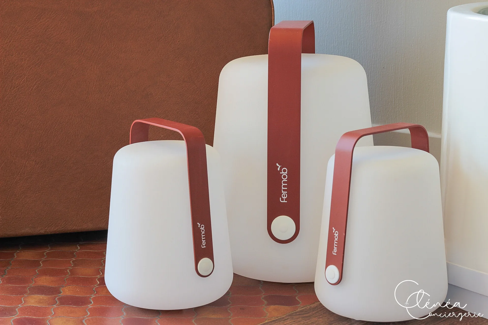 GreenOak — Trois lampes d’extérieur sans fil Fermob à anse rouge, posées au sol