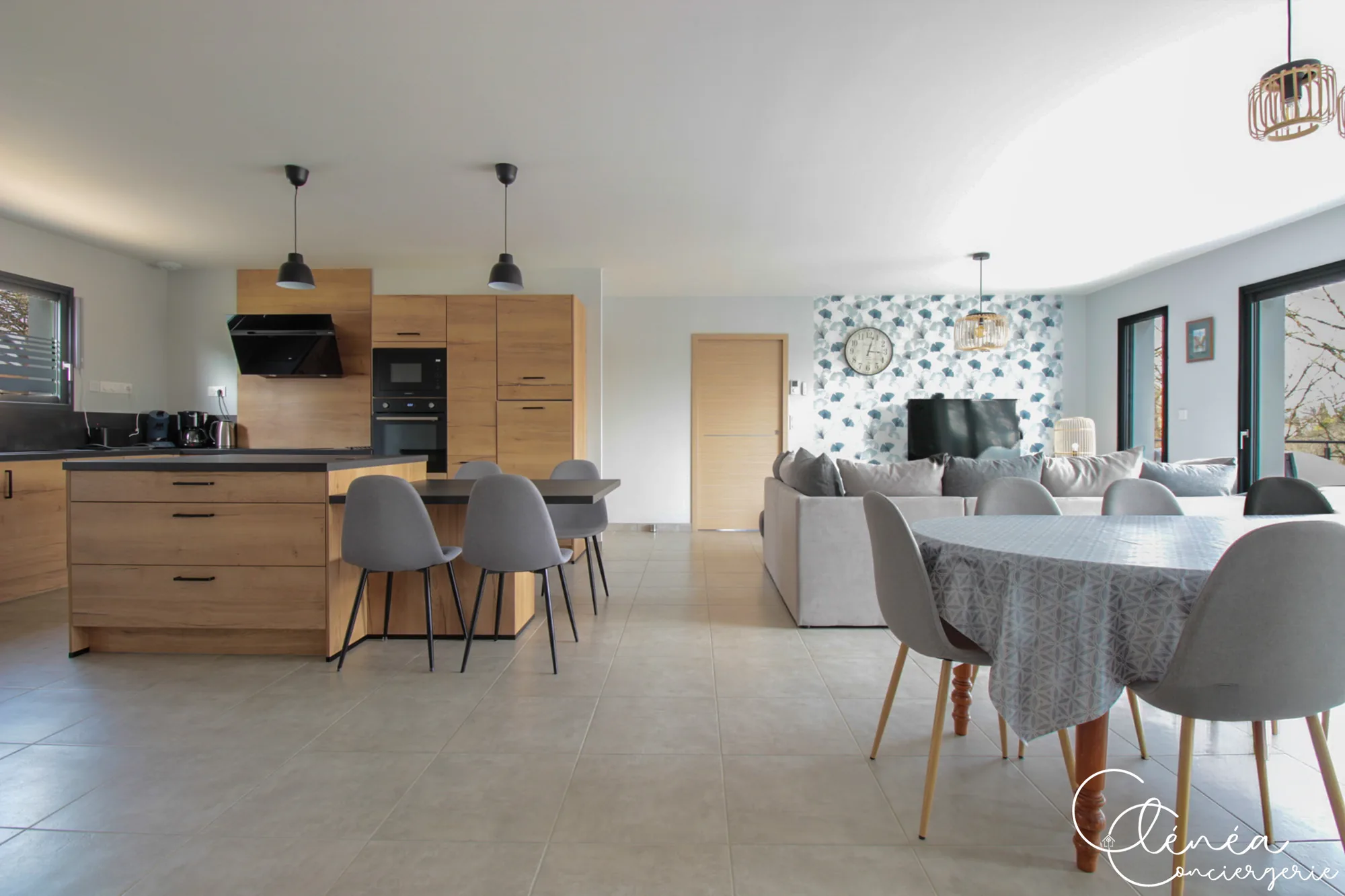 La Vigne — Vaste pièce de vie ouverte réunissant la cuisine avec îlot, la table à manger et le canapé d’angle.