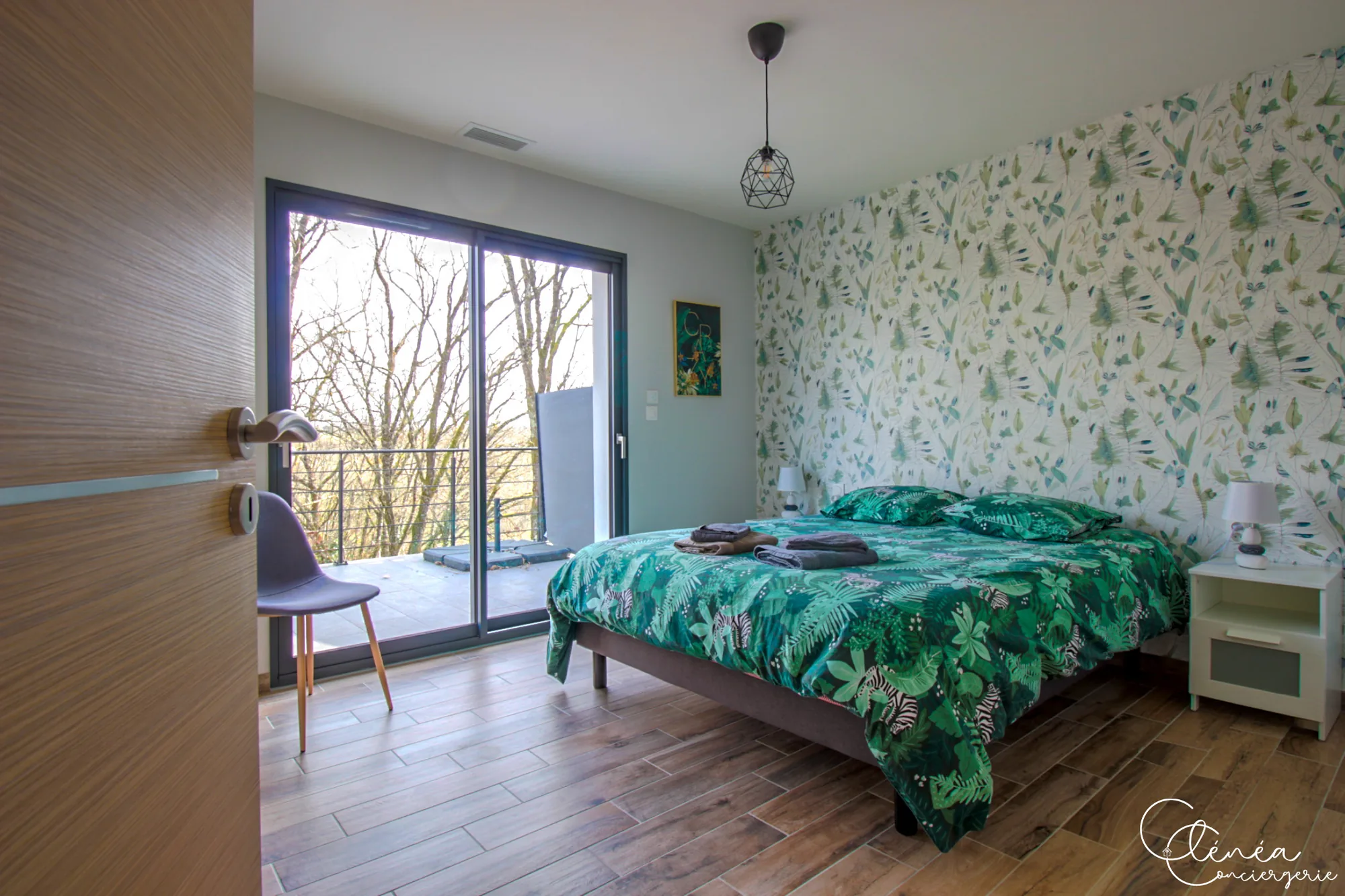 La Vigne — Chambre au papier peint végétal avec lit double et baie vitrée donnant sur la terrasse.