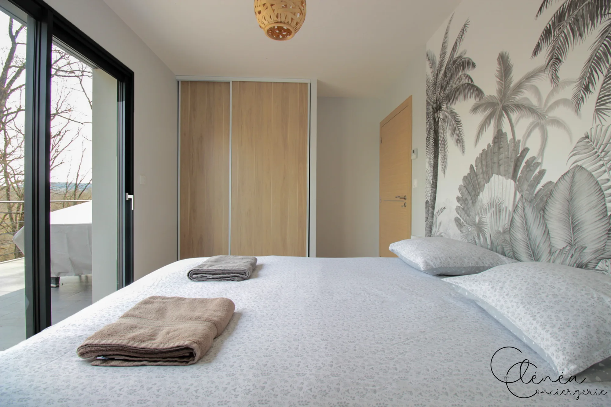 La Vigne — Lit double de la chambre 3, placard avec penderie et serviettes préparées sur le lit.