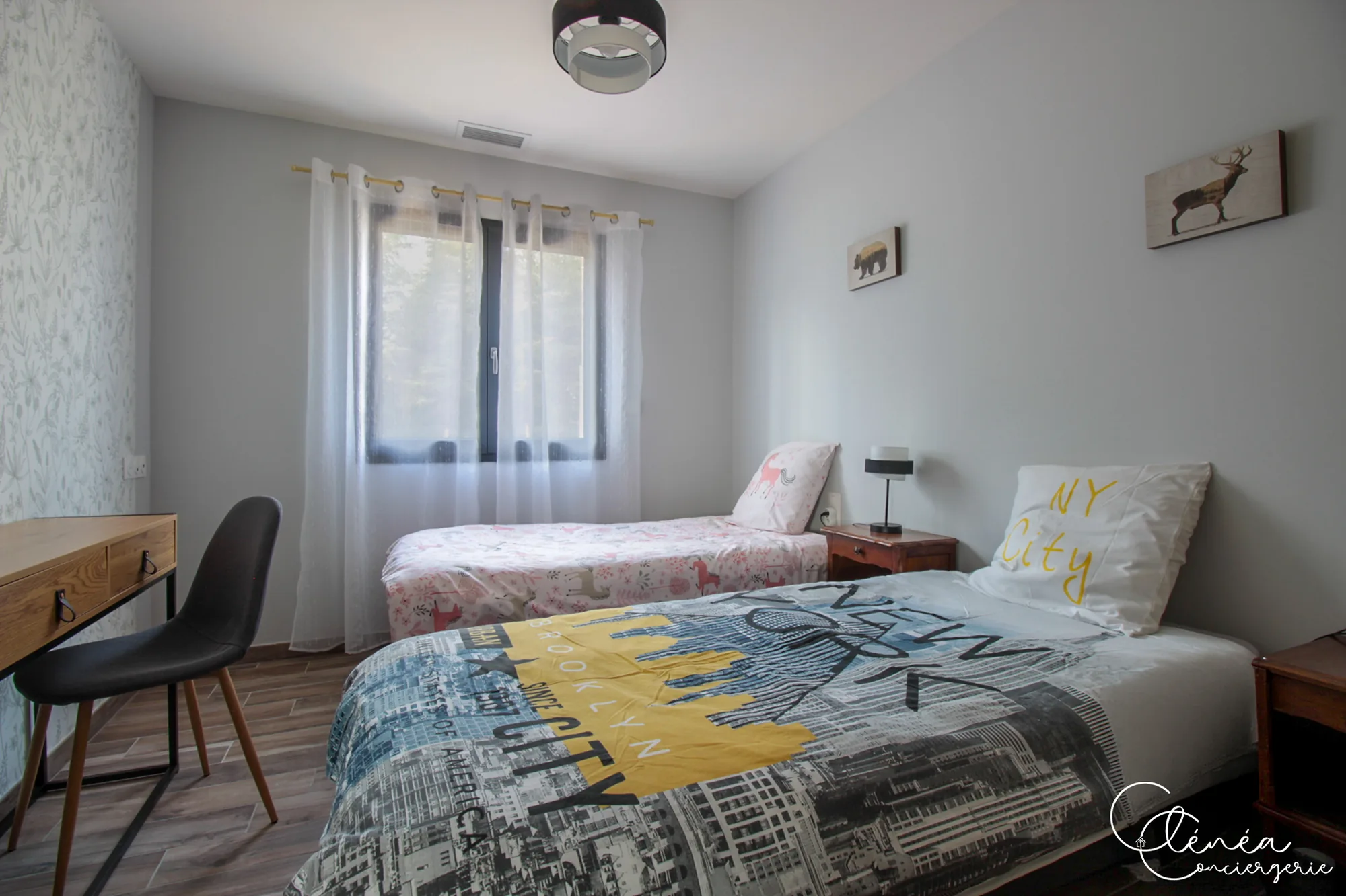 La Vigne — Chambre avec deux lits simples, un bureau en bois et sa chaise devant la fenêtre.