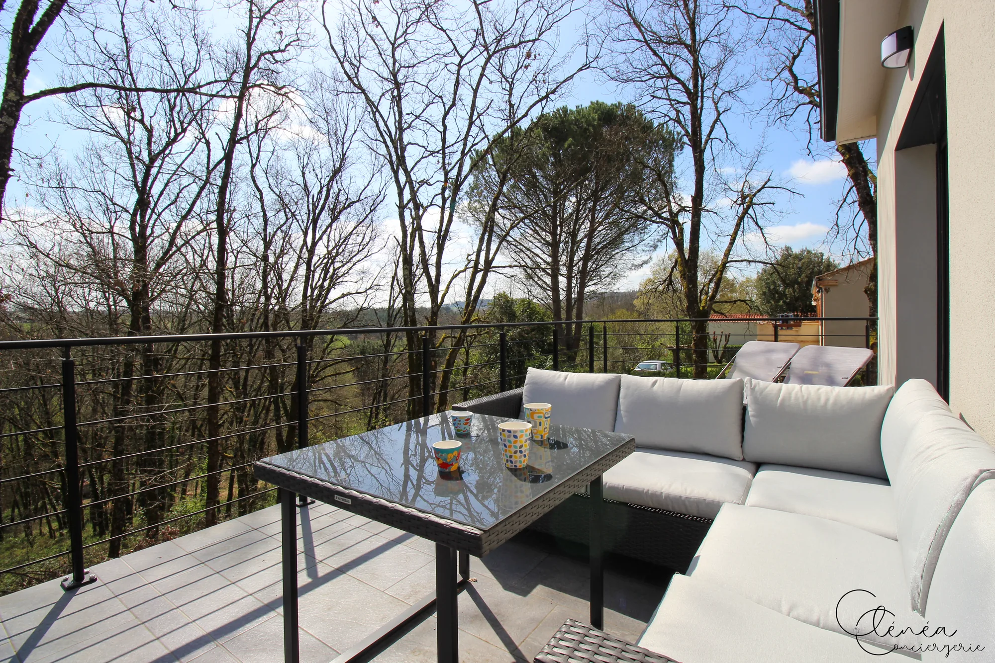 La Vigne — Coin détente de la terrasse avec canapé d’extérieur, table basse et transats.