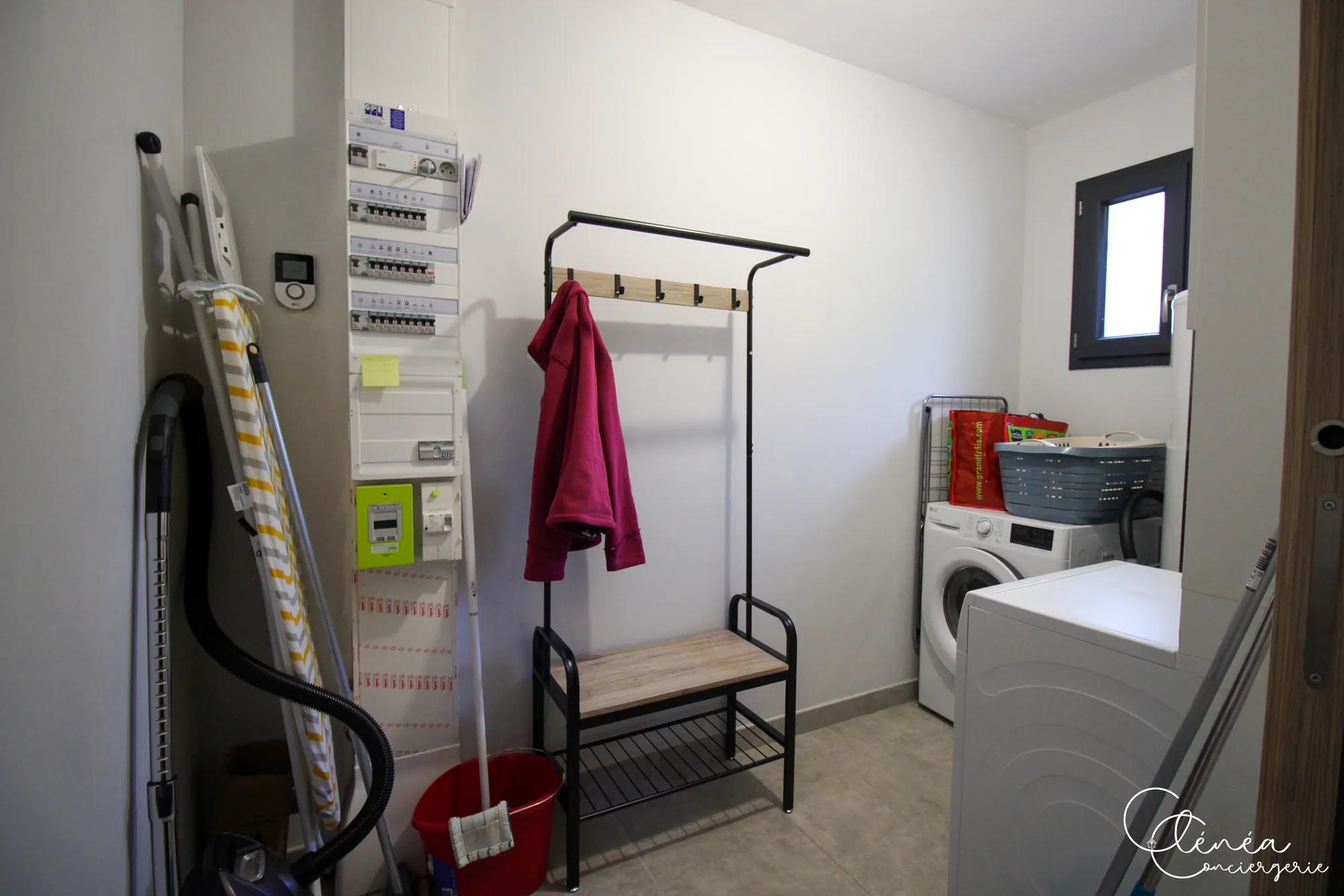 La Vigne — Buanderie équipée d’un lave-linge et d’un sèche-linge, avec table à repasser et aspirateur.