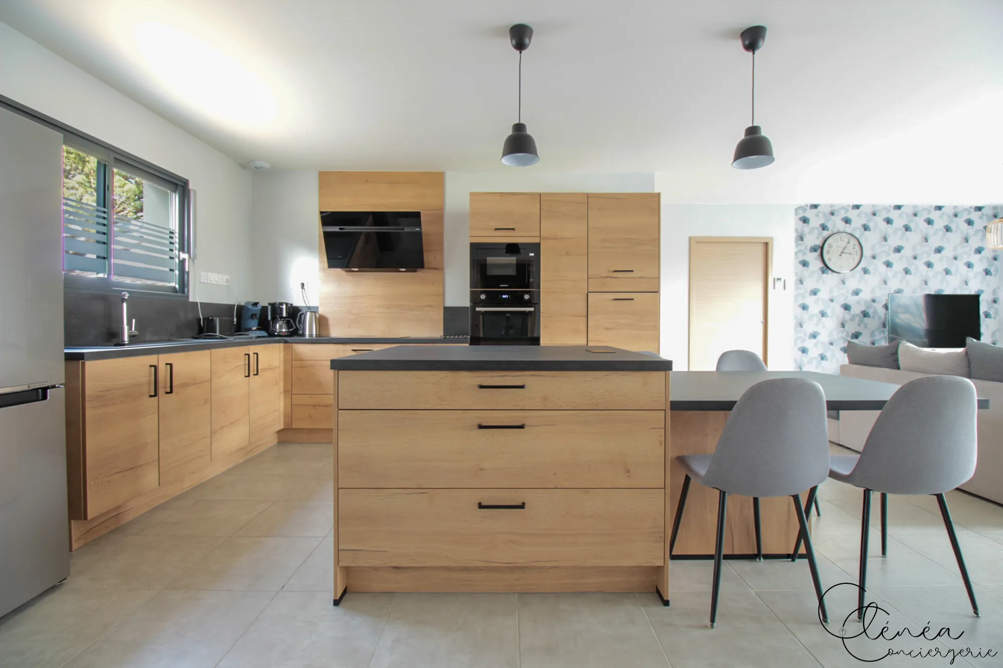 La Vigne — Cuisine équipée avec îlot central, plaques à induction, four, micro-ondes et hotte aspirante.