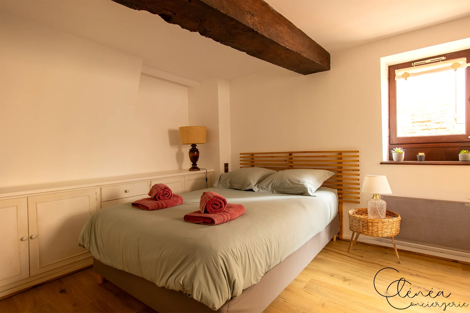 Sous les Toits de Sainte Cécile — Chambre avec lit double, tête de lit en lattes de bois, placards intégrés blancs et poutre apparente