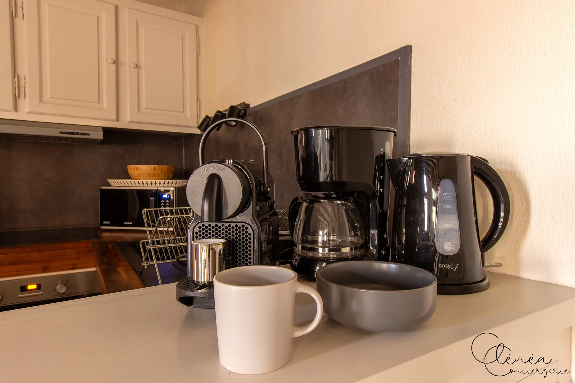 Sous les Toits de Sainte Cécile — Machine à café Nespresso, cafetière filtre et bouilloire posées sur le plan de travail