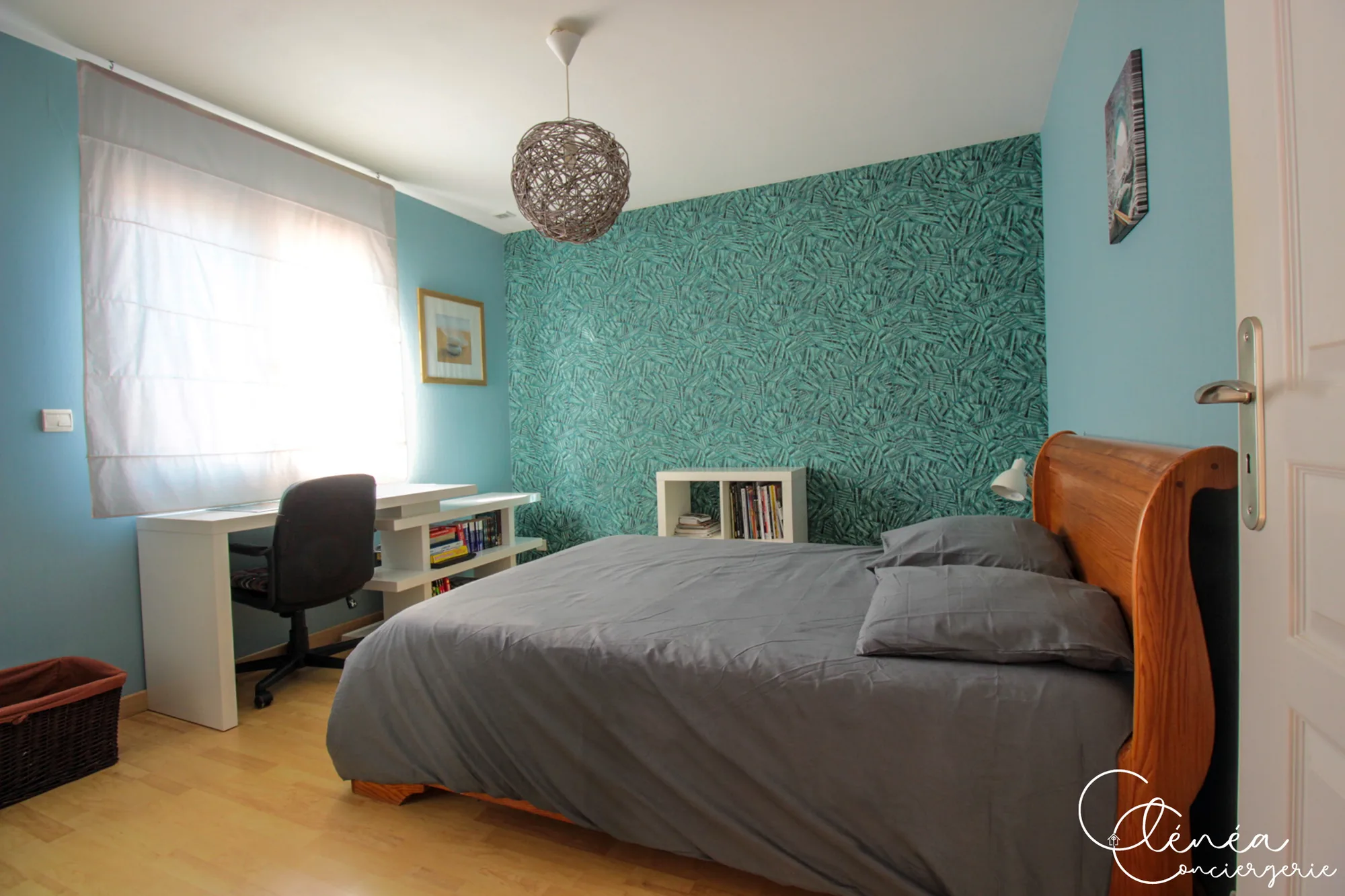 Villa Chanoine — Une chambre avec lit double en bois, papier peint turquoise et bureau blanc devant la fenêtre.
