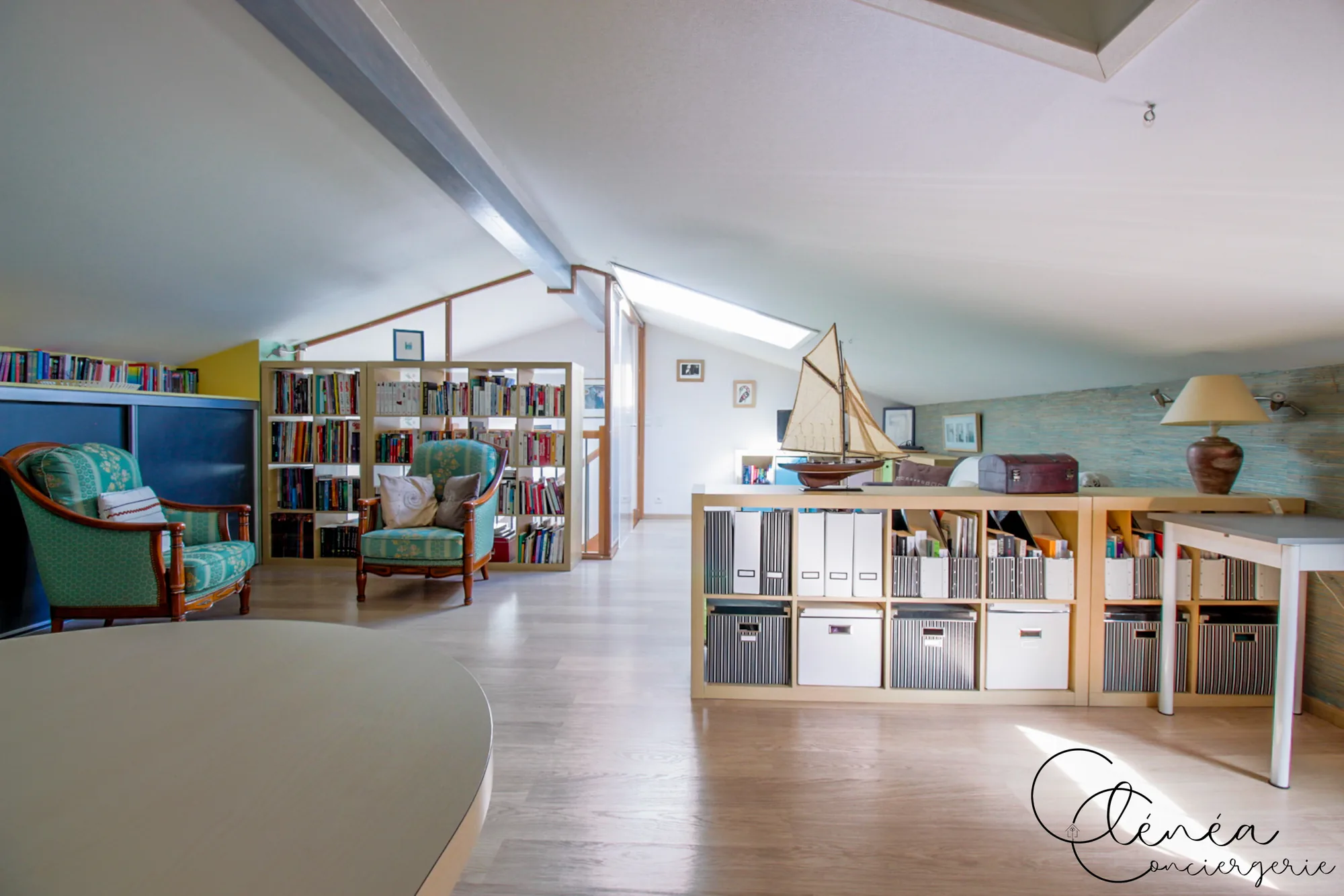 Villa Chanoine — Le coin lecture sous les combles, avec ses bibliothèques garnies de livres et deux fauteuils anciens.